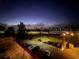 Nighttime view of a coastal property featuring manicured lawns, palm trees, and parking near a beach at 817 Wilkie St, Dunedin, FL 34698