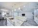 Open-concept living room featuring island seating, white sofa, and contemporary lighting fixtures at 817 Wilkie St, Dunedin, FL 34698