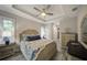 Bedroom featuring a tray ceiling, ceiling fan, a bed with a padded headboard, and shuttered windows at 817 Wilkie St, Dunedin, FL 34698