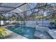 Screened pool area with waterfall feature, lush landscaping and privacy fence at 817 Wilkie St, Dunedin, FL 34698