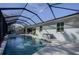 Screened pool area with lanai, outdoor furnishings, tiled deck and lush tropical landscape at 817 Wilkie St, Dunedin, FL 34698