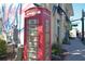 A red telephone booth stands in front of local businesses in downtown Dunedin at 817 Wilkie St, Dunedin, FL 34698