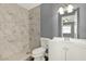 Bathroom featuring a white vanity, toilet, and a marble-tiled shower, offering a modern and clean aesthetic at 912 Lochmont Dr, Brandon, FL 33511