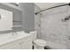 Bathroom featuring a white vanity, toilet, and a marble-tiled shower, designed for modern appeal at 912 Lochmont Dr, Brandon, FL 33511