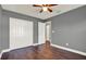 Bedroom with gray walls, hardwood floors, and a ceiling fan offering a calm and inviting space at 912 Lochmont Dr, Brandon, FL 33511