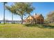 Community pool house with tan columns and brown roof surrounded by an expansive green lawn and a large shade tree at 10512 White Lake Ct, Tampa, FL 33626