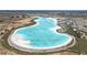 Aerial view of the community's massive aqua-blue lagoon and beach club with construction in progress at 10944 Delta Huff Ct, San Antonio, FL 33576