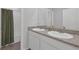 Bathroom featuring a double sink vanity with granite countertops and a shower with tile surround at 10944 Delta Huff Ct, San Antonio, FL 33576