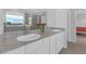 Bathroom with granite countertops, dual sinks, and glass shower with a window view at 10944 Delta Huff Ct, San Antonio, FL 33576