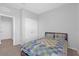 Neutral bedroom features a comfortable bed with a colorful patchwork quilt, closet and entrance to ensuite at 10944 Delta Huff Ct, San Antonio, FL 33576