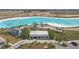 Aerial shot of a stunning welcome center and lagoon, surrounded by lush palm trees and parking at 10944 Delta Huff Ct, San Antonio, FL 33576