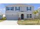 Charming two-story home with blue shutters, a well-maintained lawn, and an attached two-car garage at 10944 Delta Huff Ct, San Antonio, FL 33576