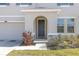 Charming entryway with an arched front door, stone accents, and manicured landscaping at 10944 Delta Huff Ct, San Antonio, FL 33576
