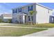 Two-story home with blue shutters, lush green lawn, and manicured landscaping at 10944 Delta Huff Ct, San Antonio, FL 33576
