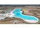 An aerial view showcases a stunning Personal-made lagoon and beach area, part of a luxurious community's amenities at 10944 Delta Huff Ct, San Antonio, FL 33576