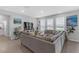 Spacious living room with large windows, comfortable seating, and view of the outdoors at 10944 Delta Huff Ct, San Antonio, FL 33576