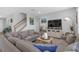 Comfortable living room with modern decor, stairs, and tiled floors at 10944 Delta Huff Ct, San Antonio, FL 33576