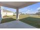 Covered patio overlooking a lush green lawn and serene pond at 10944 Delta Huff Ct, San Antonio, FL 33576