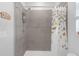 Tiled shower and tub combination with shower caddy and butterfly shower curtain at 10944 Delta Huff Ct, San Antonio, FL 33576