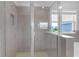 Glass door shower with tiled walls, seat, and adjacent window view of the neighborhood at 10944 Delta Huff Ct, San Antonio, FL 33576