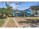 Charming blue home with black and white awnings and vibrant pink front door at 114 S Gunlock Ave, Tampa, FL 33609