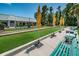 Bocce ball court with yellow umbrellas and benches surrounded by lush trees offers a relaxing outdoor recreational space at 11427 Turtle Dove Pl, New Port Richey, FL 34654