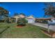 Single-Gathering home featuring a large front yard with manicured lawn, complemented by vibrant landscaping at 11427 Turtle Dove Pl, New Port Richey, FL 34654
