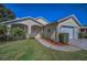 Single-Gathering home featuring a manicured lawn, vibrant landscaping, and a welcoming front porch at 11427 Turtle Dove Pl, New Port Richey, FL 34654