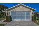 Charming home exterior showing closed garage door and beautiful landscaping at 11427 Turtle Dove Pl, New Port Richey, FL 34654