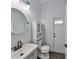 Well-lit bathroom featuring a modern sink, round mirror, and tiled floors at 1510 James L Redman Pkwy, Plant City, FL 33563