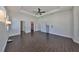 Spacious main bedroom with ceiling fan, tray ceiling, and dark wood-look tile flooring at 1510 James L Redman Pkwy, Plant City, FL 33563