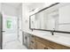 Elegant bathroom with double vanity, large mirror and lighting, and an adjacent bedroom at 28784 Rambutan Dr, Wesley Chapel, FL 33543