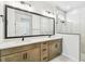Modern bathroom featuring double vanity, large mirror, tiled shower and sleek fixtures at 28784 Rambutan Dr, Wesley Chapel, FL 33543