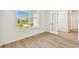 Bright bedroom with hardwood floors and a large window offering scenic neighborhood views at 28784 Rambutan Dr, Wesley Chapel, FL 33543