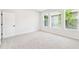 Cozy carpeted bedroom with three windows, recessed lighting, and a simple door at 28784 Rambutan Dr, Wesley Chapel, FL 33543
