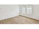 Bright bedroom with wood floors, two windows, and neutral walls at 28784 Rambutan Dr, Wesley Chapel, FL 33543