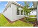 Exterior view of the home, showing the neutral-colored exterior and mulched flower beds by the windows at 28784 Rambutan Dr, Wesley Chapel, FL 33543