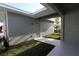 Enclosed back patio area with a door and an exterior light fixture with manicured lawn at 28784 Rambutan Dr, Wesley Chapel, FL 33543