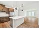 Modern kitchen with stainless steel appliances, a center island, and hardwood floors creates a seamless flow to the dining area at 28784 Rambutan Dr, Wesley Chapel, FL 33543