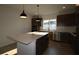 Bright kitchen with an island, modern pendant lighting, stainless steel appliances, and wooden cabinets at 28784 Rambutan Dr, Wesley Chapel, FL 33543