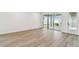 Spacious living room with light wood flooring and sliding glass doors leading to outdoor patio at 28784 Rambutan Dr, Wesley Chapel, FL 33543