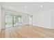 Bright living room featuring wood floors, recessed lighting, and sliding glass doors to an outdoor space at 28784 Rambutan Dr, Wesley Chapel, FL 33543