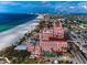 Stunning aerial view of a pink historic resort along a beautiful white sand beach at 3390 W Maritana Dr # 4, St Pete Beach, FL 33706