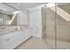 Modern bathroom featuring double sinks, a large mirror, and a glass-enclosed shower with skylight at 3390 W Maritana Dr # 4, St Pete Beach, FL 33706