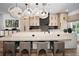 Modern kitchen featuring a large island with seating, pendant lights, and light wood cabinets at 3390 W Maritana Dr # 4, St Pete Beach, FL 33706