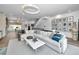 Bright, open-concept living room with modern decor, a large sectional sofa, and stylish light fixtures at 3390 W Maritana Dr # 4, St Pete Beach, FL 33706
