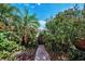 Charming walkway leading through lush tropical foliage to a private gate at 3390 W Maritana Dr # 4, St Pete Beach, FL 33706