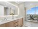A modern bathroom featuring double sinks, a glass shower and a balcony overlooking the city skyline at 5120 Marina Way # 15006, Tampa, FL 33611