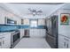 Modern kitchen with stainless steel appliances, white cabinetry, and stylish blue backsplash at 5130 Brittany S Dr # 201, St Petersburg, FL 33715