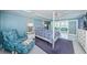 Well-lit bedroom boasts light blue walls, stylish furniture, and view to living area at 5130 Brittany S Dr # 201, St Petersburg, FL 33715